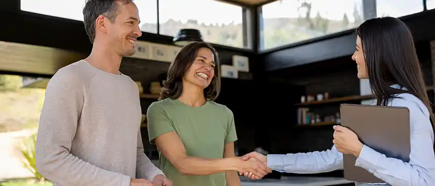 woman with partner shakes the hand of a businessman